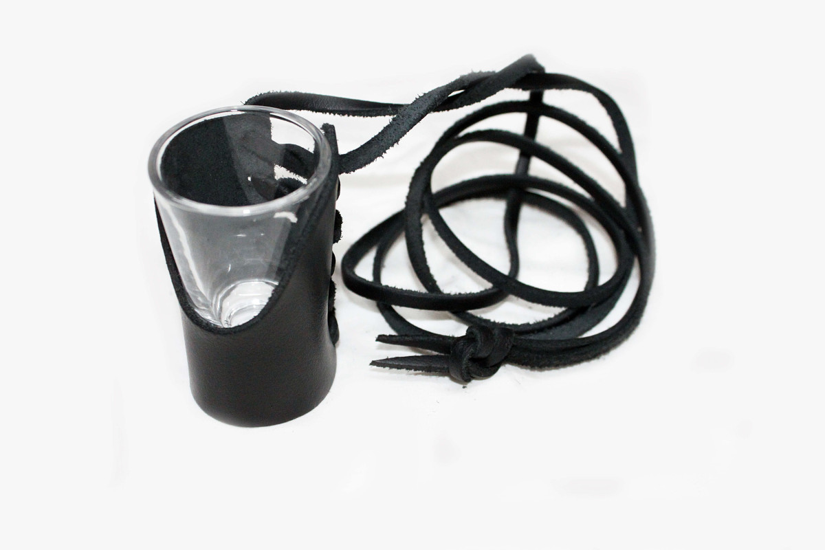 Ein hängendes Schnapsglas im Leder mit einem  Riemen